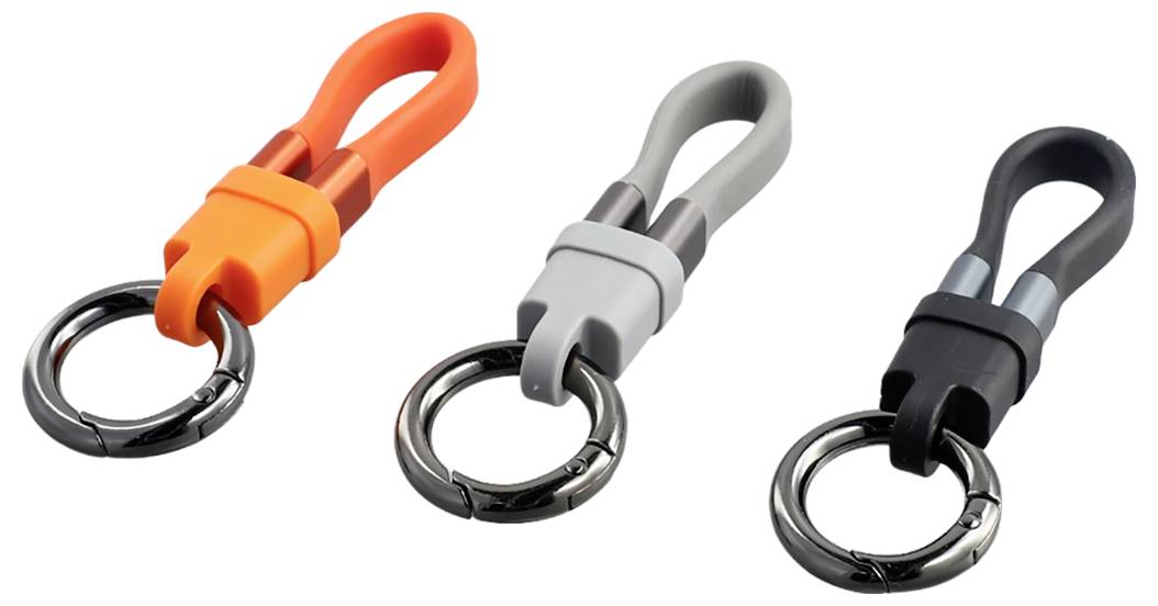 Drei Silikon-Schlüsselanhänger-Schlaufen mit Metallschlüsselringen in Orange, Grau und Schwarz auf weißem Hintergrund.