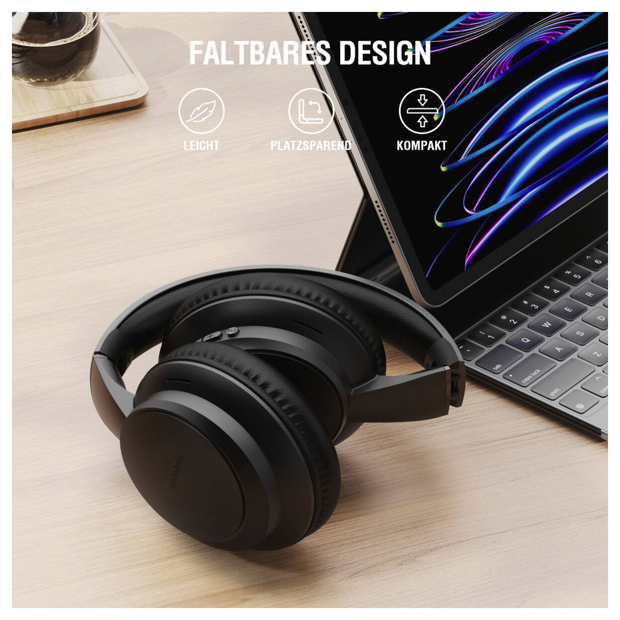 Schwarze Over-Ear-Kopfhörer auf einem Schreibtisch neben einer zusammengeklappten Tablet-Tastaturhülle, mit dem Text „FALTBARES DESIGN" und Symbolen für leicht, platzsparend und kompakt.