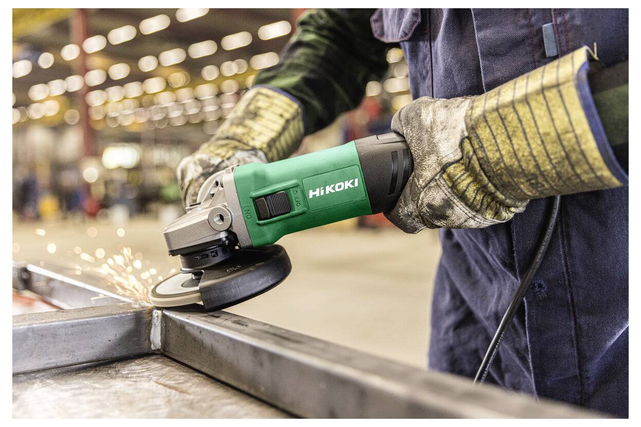 Arbeiter, der einen Winkelschleiffer auf einem Metallstück verwendet und dabei Funken in einer Werkstatt erzeugt.