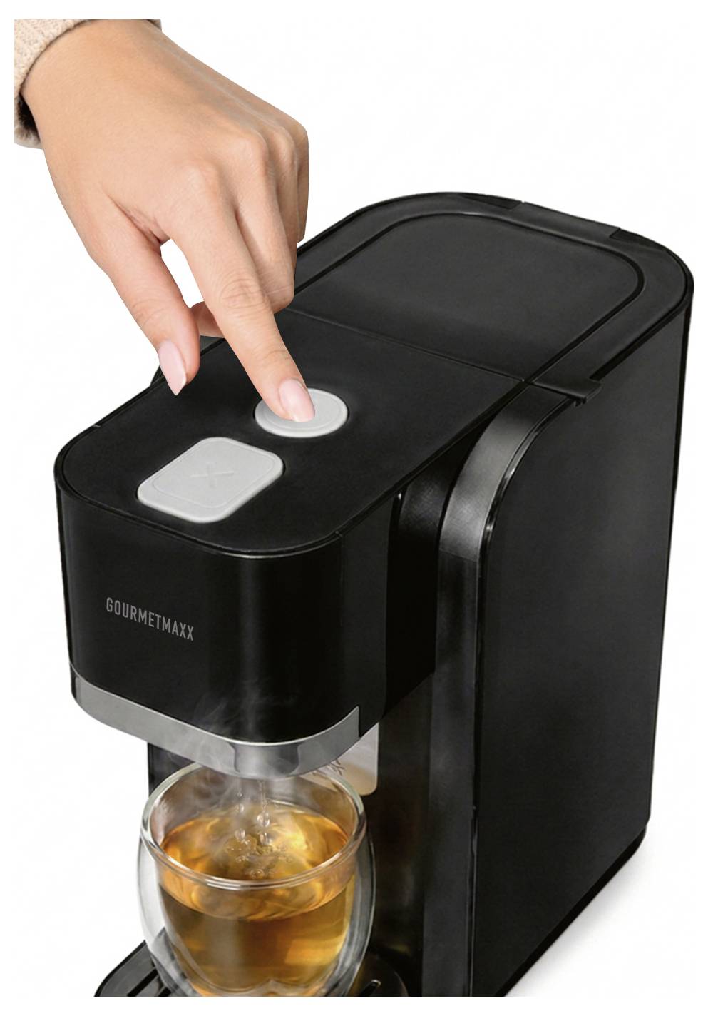 Hand drückt einen Knopf an einer Einzelportionen-Kaffeemaschine, während sich unter dem Auslauf ein Glaskaffee- oder Teeglas braut.