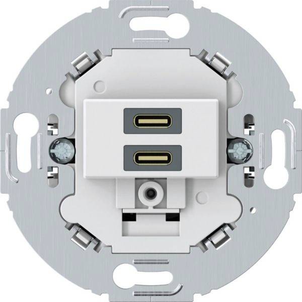 Wandmontierte Steckdosenblende mit zwei USB-C-Ladeanschlüssen und einer Standard-Steckdosenöffnung in der Mitte.