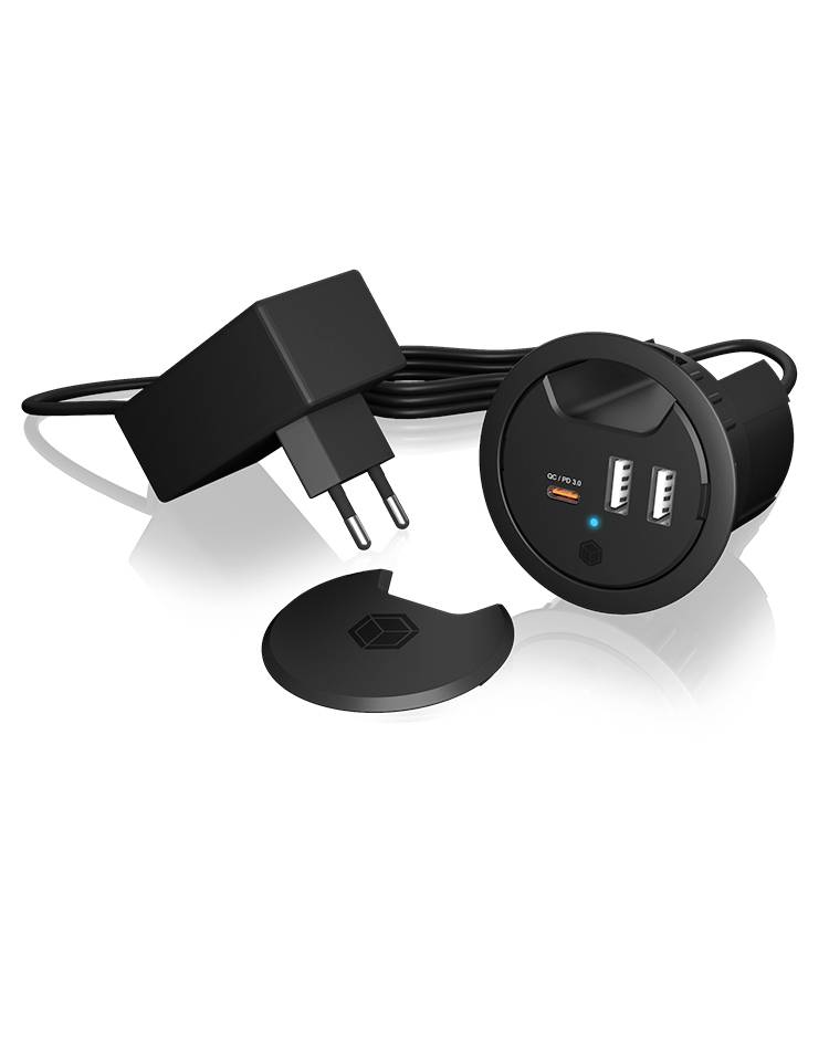 Schwarze USB-Ladegerätset mit Stromadapter, rundes Hub mit zwei USB-Anschlüssen und Klappdeckel, plus eine kleine passende Kappe auf weißem Hintergrund.
