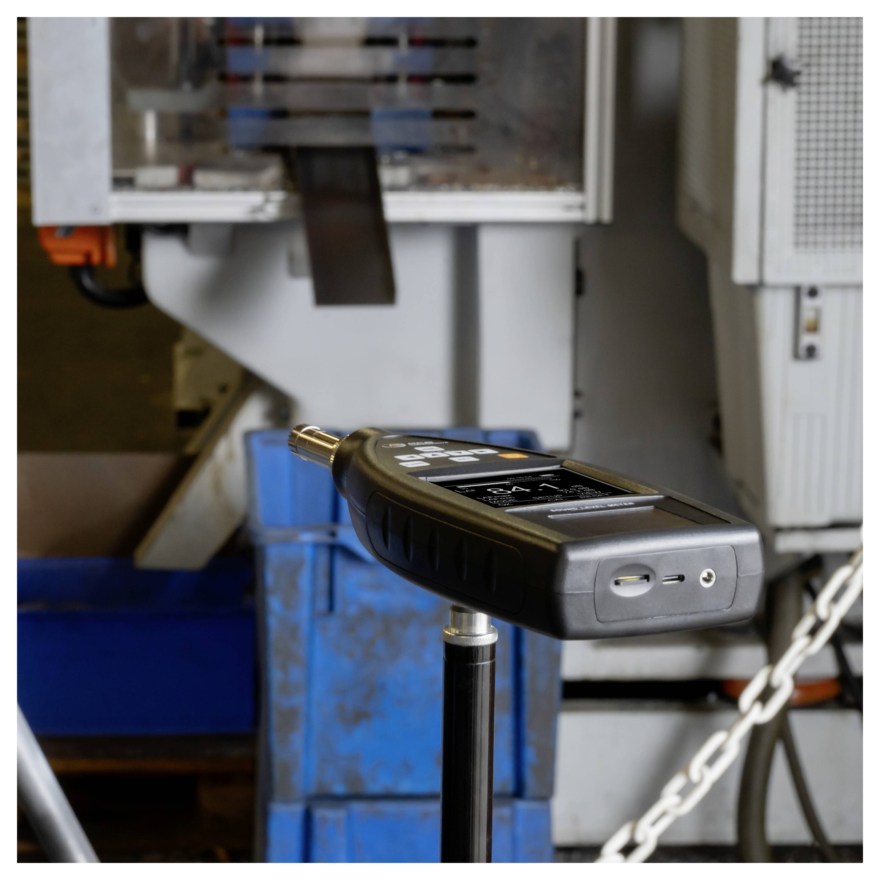 Tragbares Inspektionsgerät für die Industrie, das auf einem Ständer vor Maschinen montiert ist, mit einer Sonde, die auf die Ausrüstung zum Messen oder Testen ausgerichtet ist.