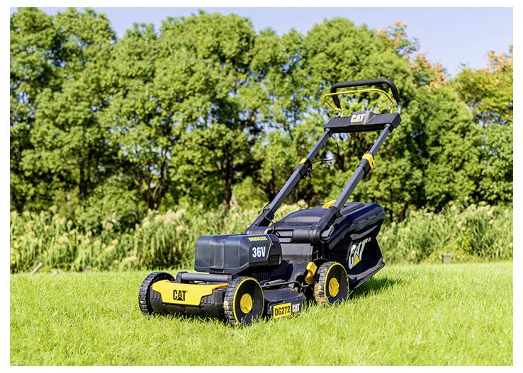 Schwarz-gelber CAT 36V Rasenmäher auf einem grasbewachsenen Feld mit Bäumen im Hintergrund.
