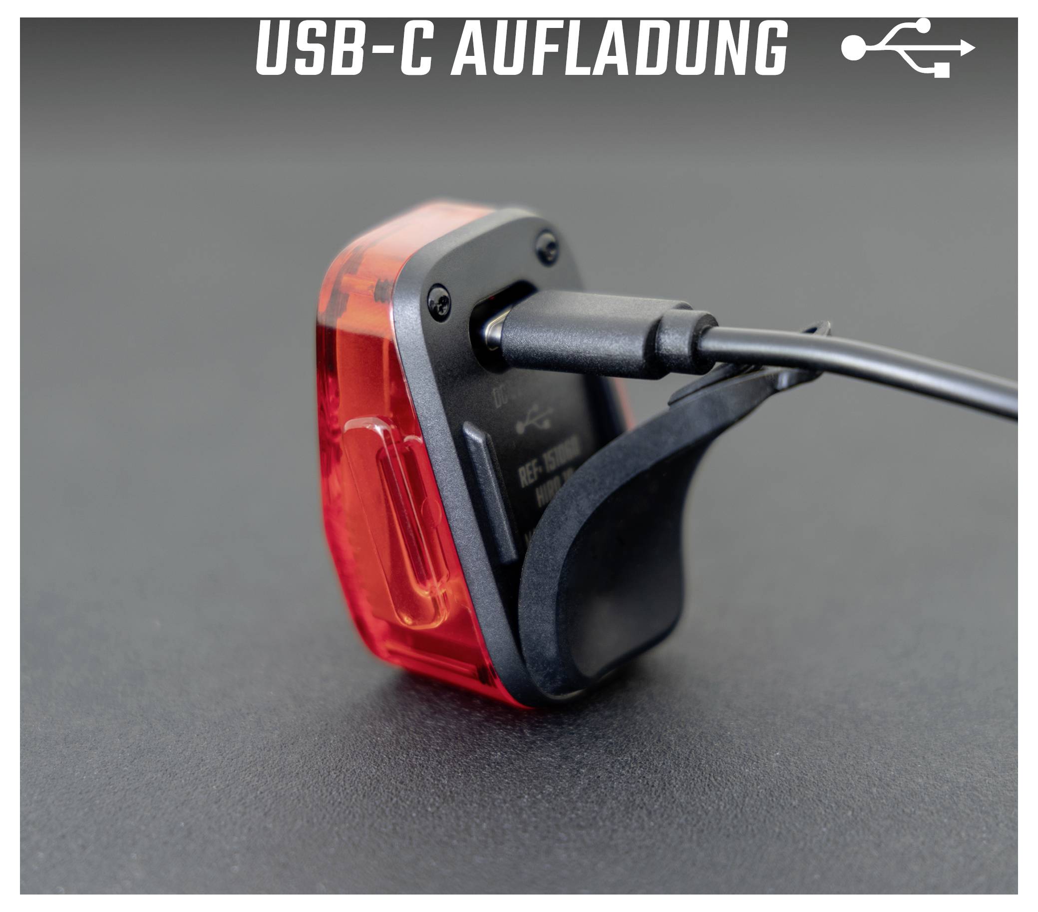 Rücklicht mit eingestecktem USB-C-Ladekabel; oben steht 'USB-C AUFLADUNG' mit USB-Symbol.