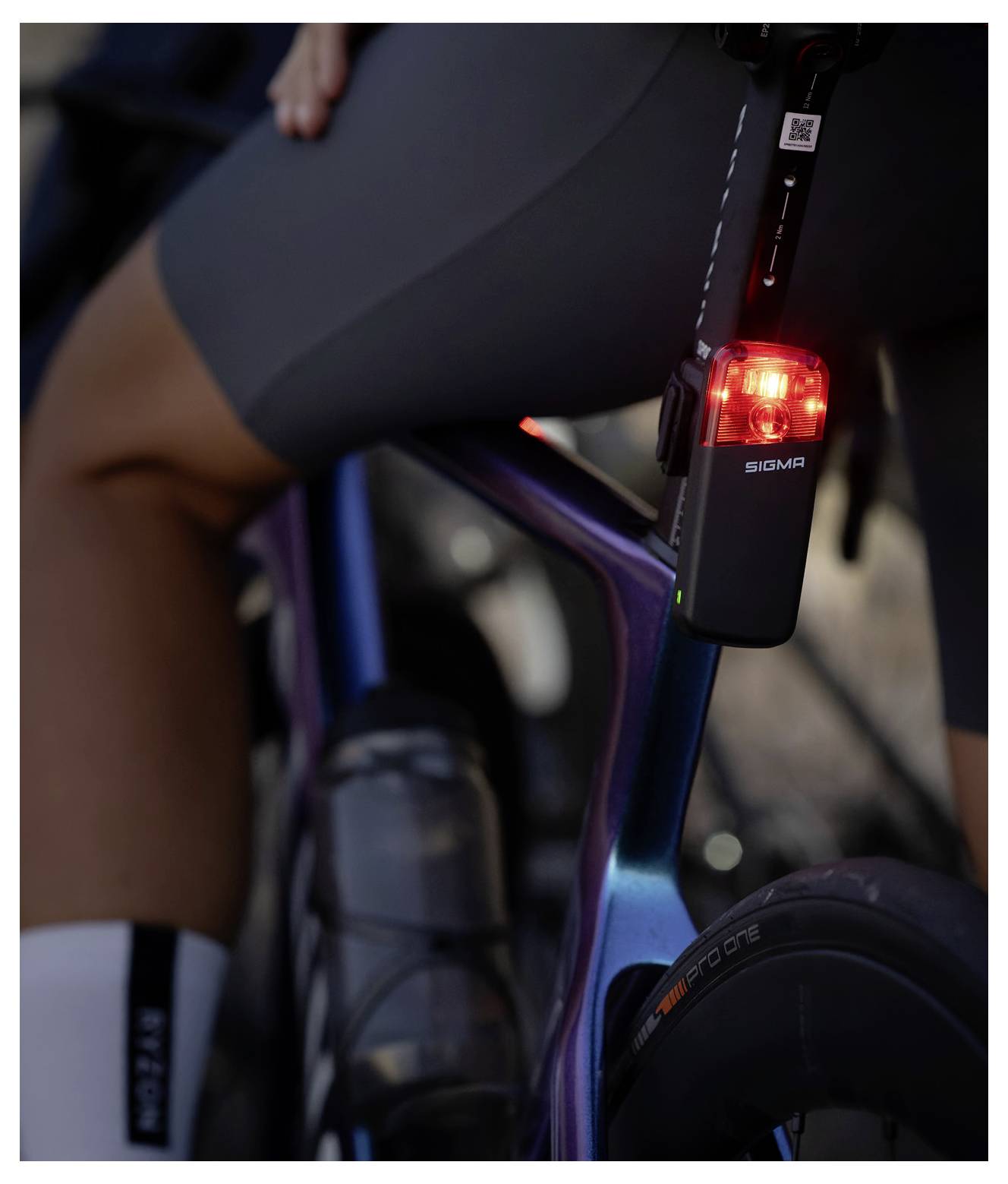 Nahaufnahme eines Fahrrads eines Radfahrers mit einem leuchtend roten hinteren Sicherheitslicht, das an der Sattelstütze befestigt ist.