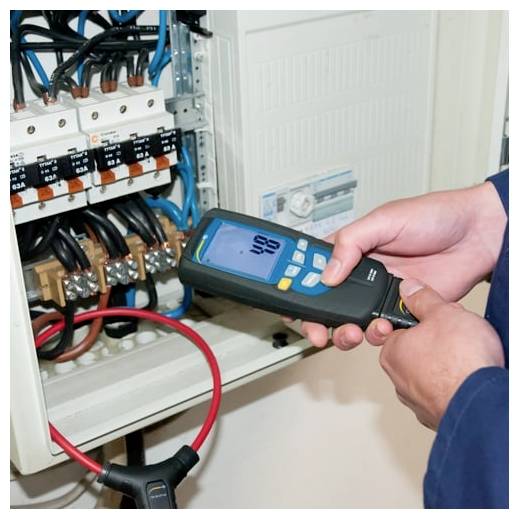 Techniker, der ein tragbares Elektrotestgerät an der Verkabelung innerhalb eines offenen Schutzschalterfeldes verwendet.