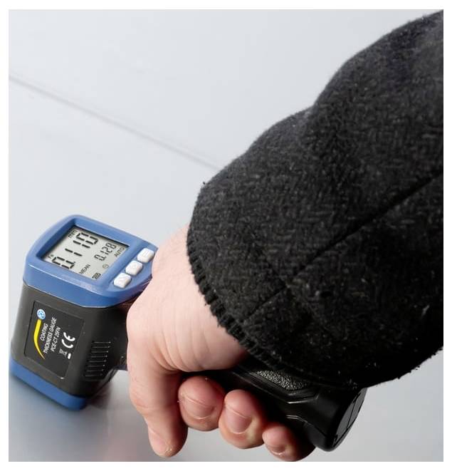 Tragbares digitales Infrarot-Thermometer, das auf eine Oberfläche gerichtet ist und eine Temperaturanzeige auf seinem Display zeigt.