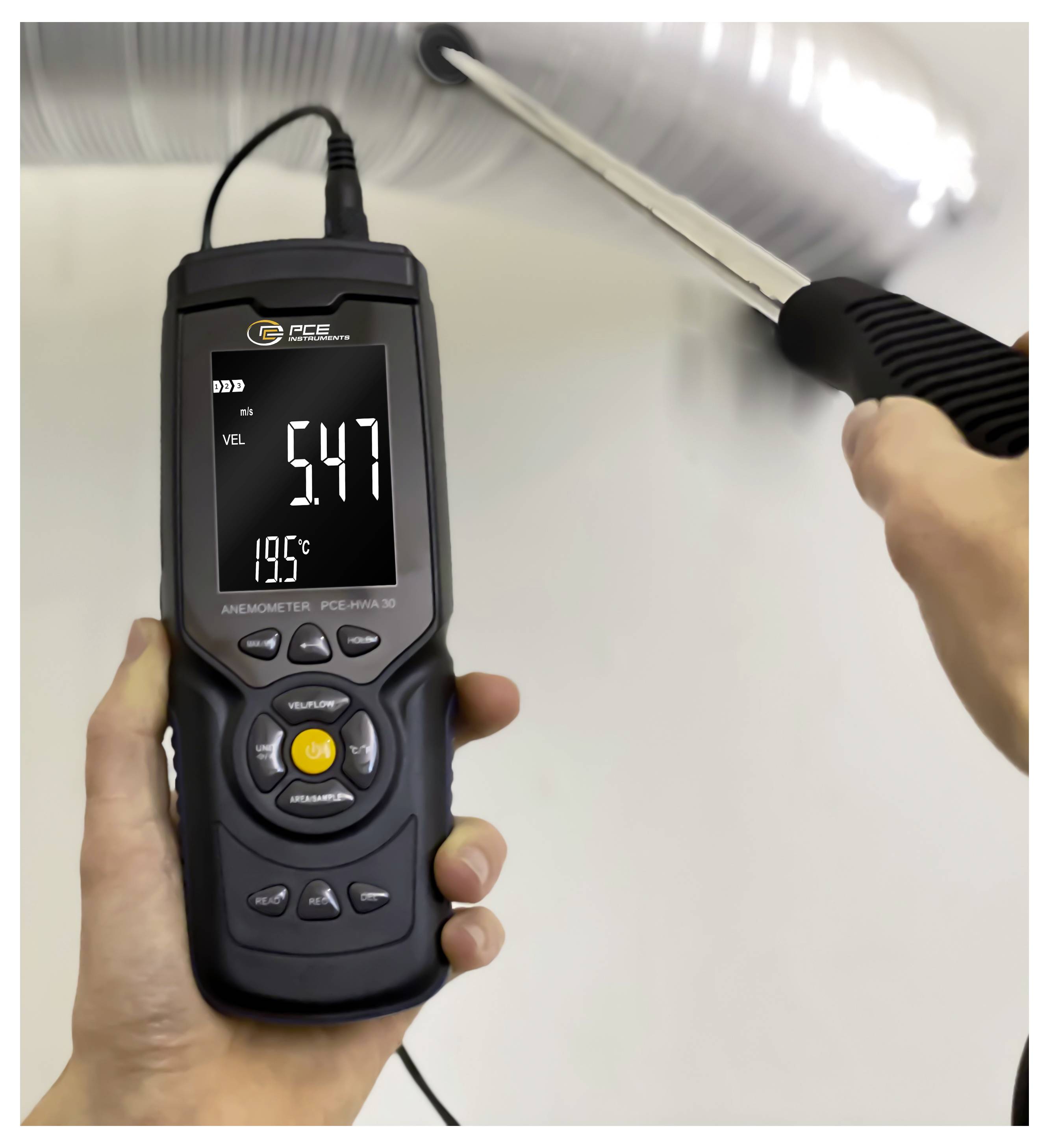Tragbares Anemometer, das die Luftgeschwindigkeit aus einer Deckenöffnung misst und 5,47 und 19,7°C auf dem Bildschirm anzeigt.