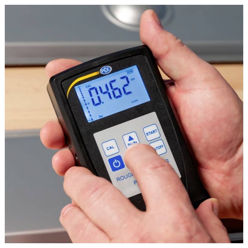 Hände, die ein tragbares digitales Messinstrument verwenden, das auf einem blaubeleuchteten Display einen Wert von 0,462 anzeigt.