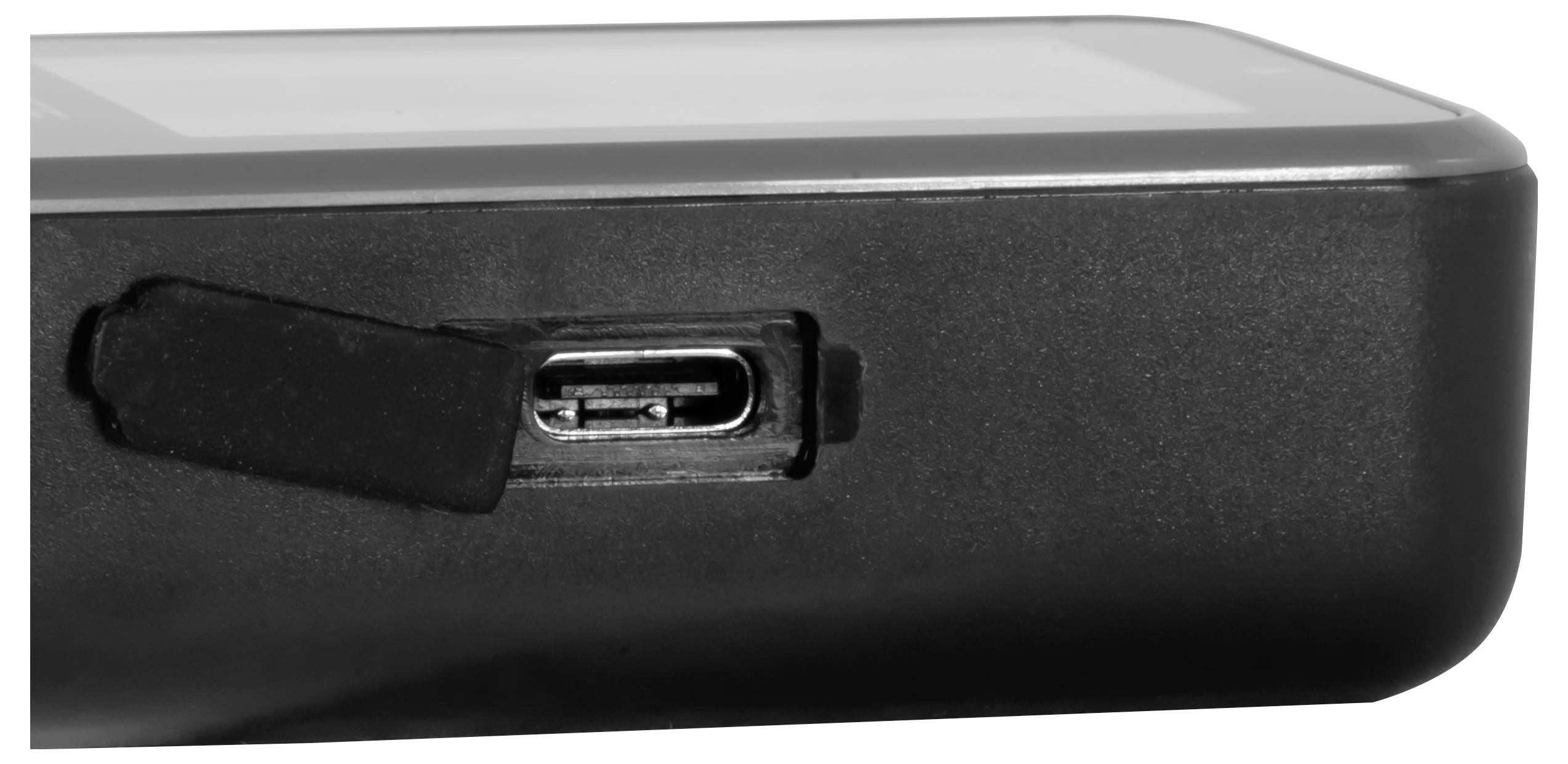 Nahaufnahme einer Ecke eines schwarzen elektronischen Geräts mit einem abgedeckten USB-C-Ladeanschluss.