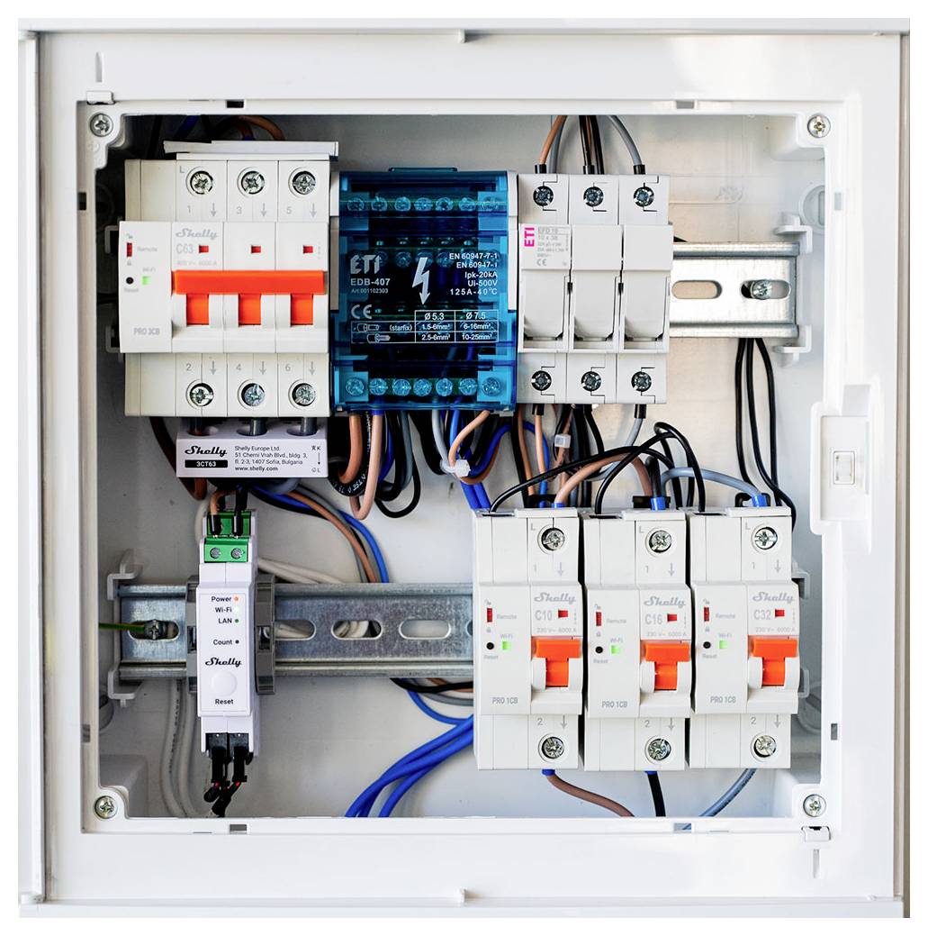 Offenes Verteilerpanel mit mehreren Leitungsschutzschaltern, Relais und verdrahteten Modulen auf DIN-Schienen montiert.