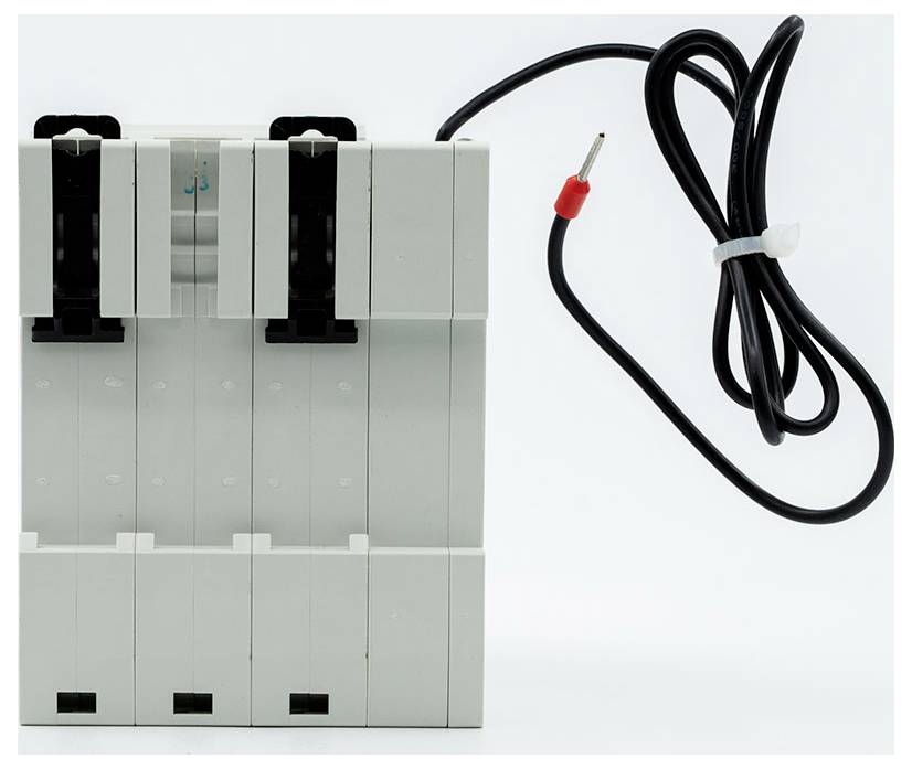 Elektrisches Steuermodul mit schwarzem Kabel und rot-gespitztem Stecker, abgebildet neben einem grauen Gehäuse mit mehreren Steckplätzen.
