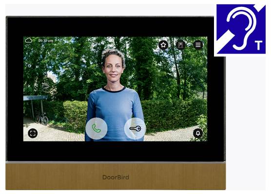 DoorBird-Videosprechanlage zeigt eine Frau am Eingang, mit einem Symbol für Hörhilfe, das barrierefreie Audiounterstützung anzeigt.