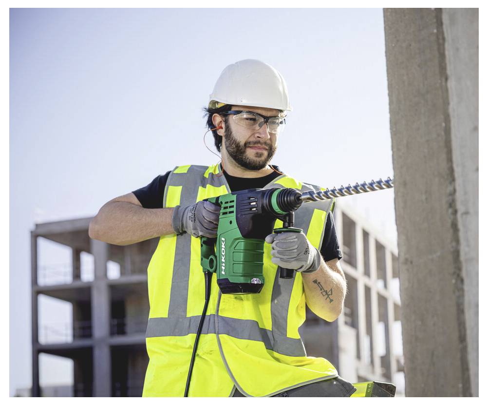 Bauarbeiter mit Schutzhelm und Warnweste, der einen Elektroschrauber auf einer Baustelle benutzt.