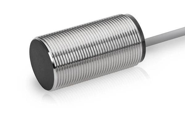 Nahaufnahme eines zylindrischen Gewindemetallsensors oder Stellantriebs mit einem hervorstehenden grauen Kabel auf weißem Hintergrund.