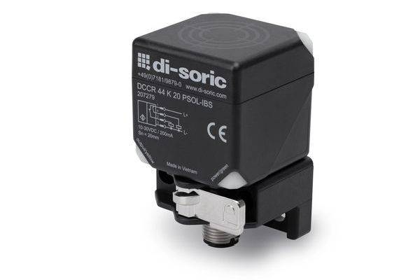 Schwarzes Di-Soric-Elektrosensormodul mit beschrifteter Vorderseite und Montagebügel auf weißem Hintergrund.