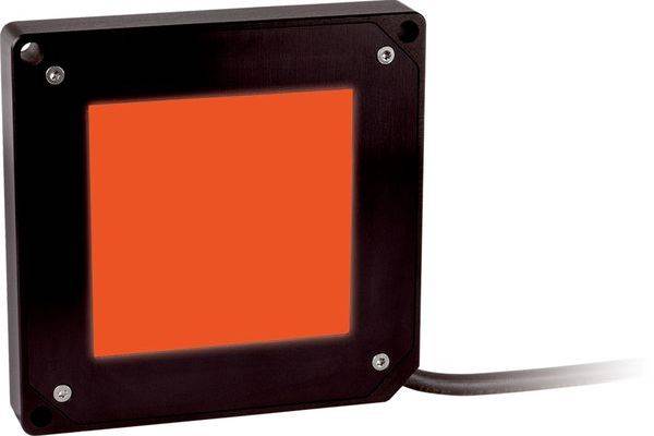 Schwarzer quadratischer Industriesensor oder Anzeigelampe mit leuchtendem orangefarbenem Mittelpunkt und angeschlossenem Kabel auf der rechten Seite.