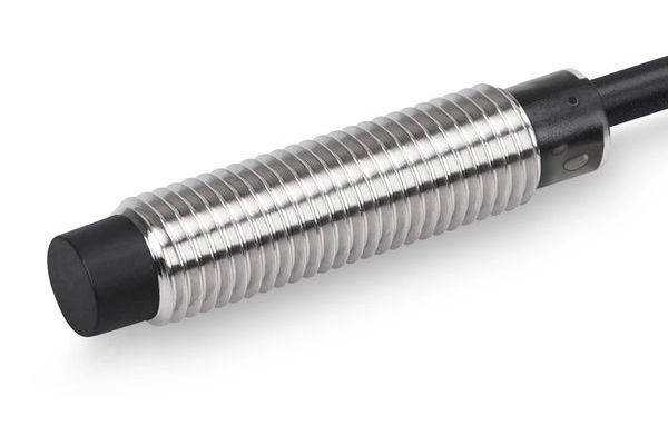Nahaufnahme eines zylindrischen Metallsensors oder einer Sonde mit einem schwarzen Kabelende, dargestellt vor einem weißen Hintergrund.