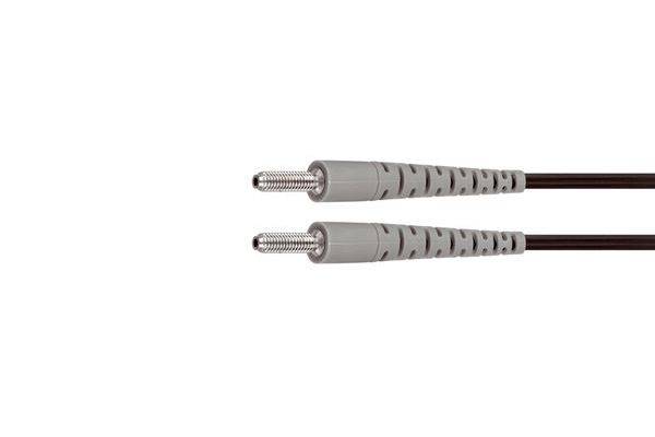 Zwei graue Glasfaserstecker mit metallischen Gewinde-Anschlüssen auf schwarzen Kabeln, nebeneinander auf weißem Hintergrund gezeigt.