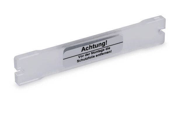 Weiße Kunststoffschutzabdeckung mit Etikett mit der Aufschrift „Achtung! Vor der Montage die Schutzfolie entfernen!