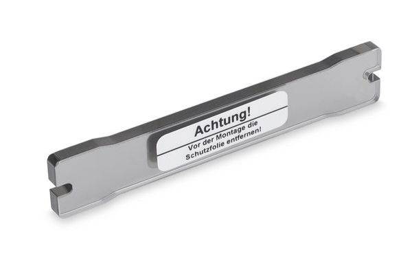 Metallwerkzeug oder Montageleitfaden mit Warnschild mit der Aufschrift „Achtung! Vor der Montage die Schutzfolie entfernen!