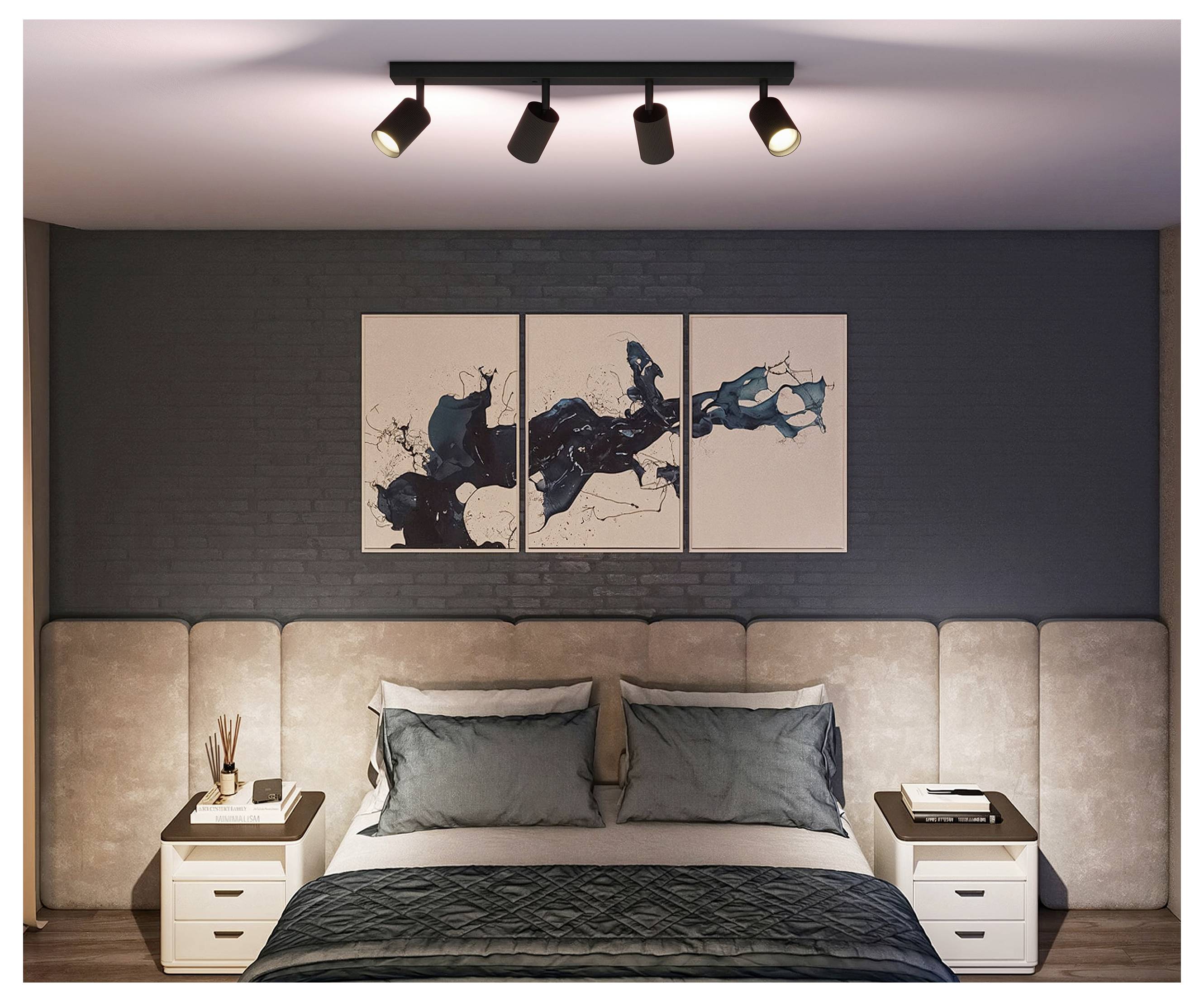 Modernes Schlafzimmer mit einem ordentlich gemachtem Bett, zwei Nachttischen, Wandkunst über dem Kopfteil und Schienensystem-Beleuchtung an der Decke.