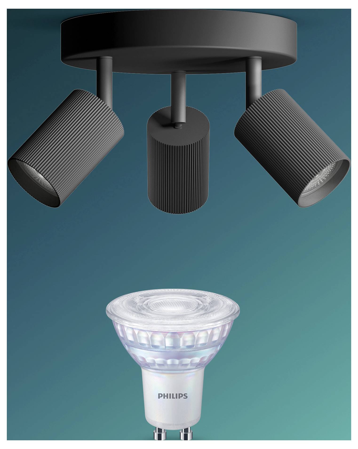 Drei verstellbare Deckenspots strahlen nach unten auf eine Philips LED-Lampe vor blaugrünem Hintergrund.