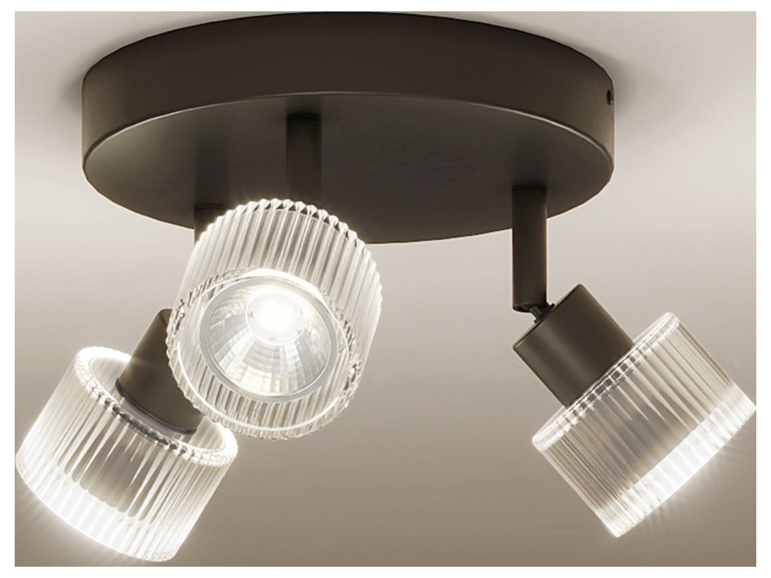 Drei-Lampen-Deckenleuchte mit dunkler runder Halterung und verstellbaren gerippten Glassschirmen, einer in der Mitte und zwei nach außen geneigt.