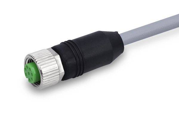 Nahaufnahme eines grauen Kabels mit einem schwarz-silbernen runden Stecker, wobei eine grüne Stifteinsatzfeder gegen einen weißen Hintergrund zu sehen ist.