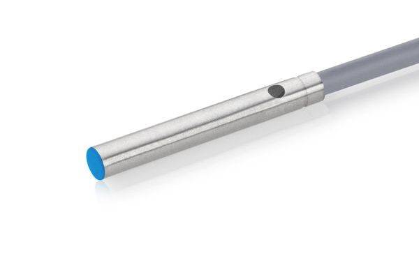 Nahaufnahme einer silbernen zylindrischen Sonde oder eines Sensors mit einer blauen Spitze, die an einem grauen Kabel auf weißem Hintergrund befestigt ist.