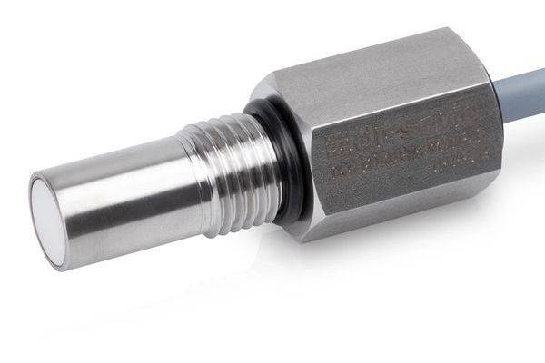 Nahaufnahme einer Metallkabelgarnitur oder eines Steckers mit einer gewindelten silbernen Spitze und sechskantigem Gehäuse, das an einem grauen Kabel auf weißem Hintergrund befestigt ist.