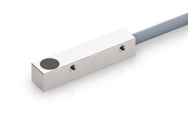 Nahaufnahme eines metallischen rechteckigen Sensors oder einer Sonde mit angeschlossenem Kabel, dargestellt auf weißem Hintergrund.