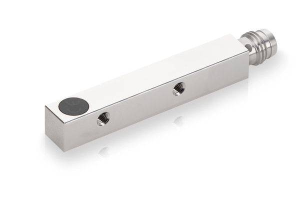 Silberner rechteckiger Metallsensor oder Steckerkomponent mit Gewinde am Ende und zwei Seitenlöchern, dargestellt auf weißem Hintergrund.