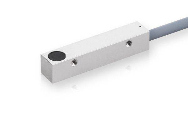 Nahaufnahme eines rechteckigen Metall-Sensor- oder Steckverbinderblocks mit angeschlossenem Kabel, dargestellt auf weißem Hintergrund.