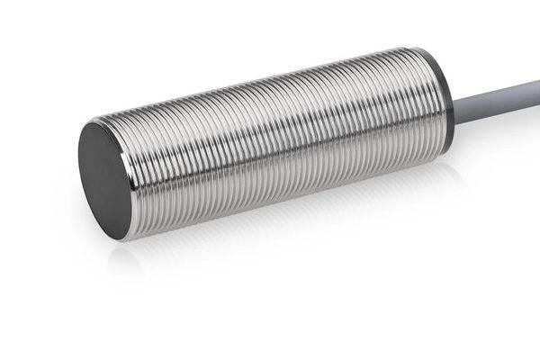 Nahaufnahme eines zylindrischen Metallnäherungssensors mit Gewinde am Körper und einem Kabel, das von einem Ende abgeht, isoliert auf weißem Hintergrund.