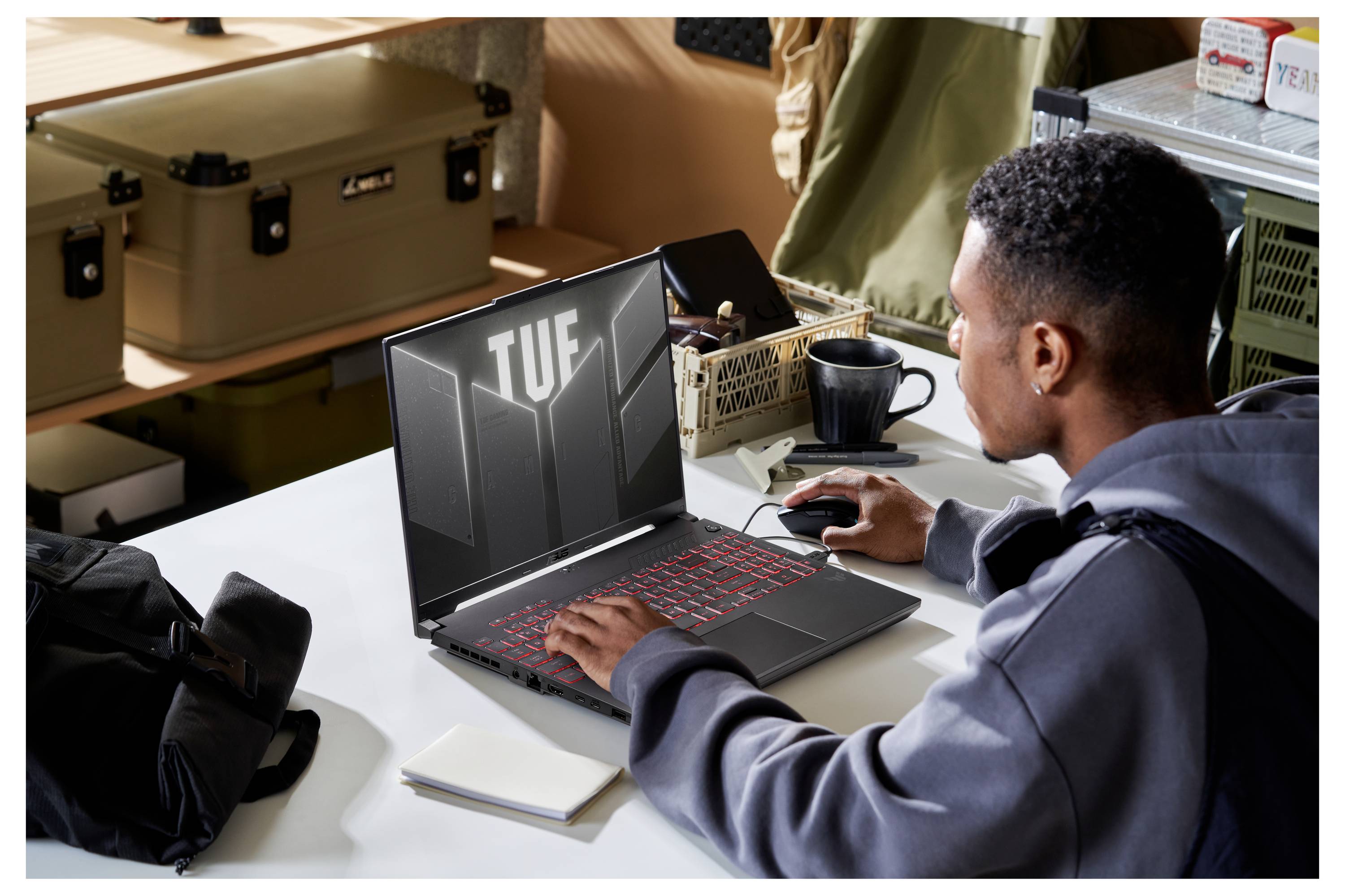 Person, die an einem Schreibtisch einen Laptop benutzt; der Bildschirm zeigt „TUF
