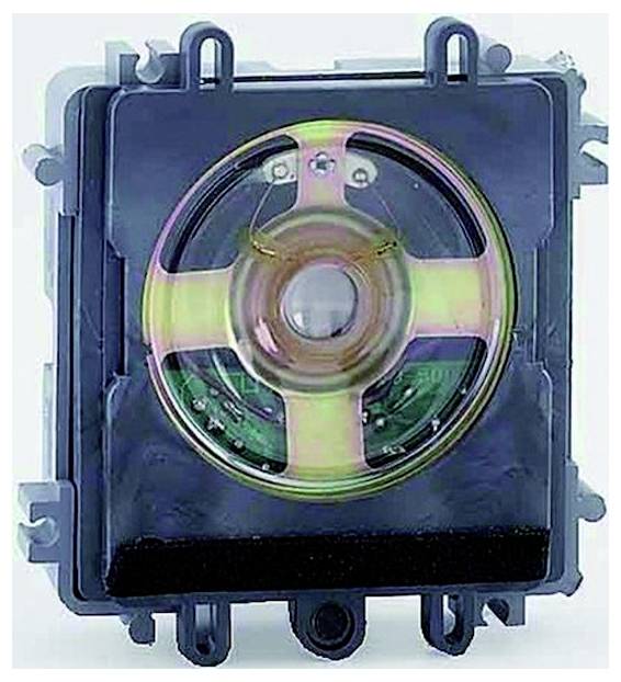 Nahaufnahme einer kreisförmigen elektronischen Komponente oder einem lautsprecherähnlichen Gerät in einem schwarzen quadratischen Gehäuse mit Befestigungslaschen und sichtbarer innerer Schaltung.