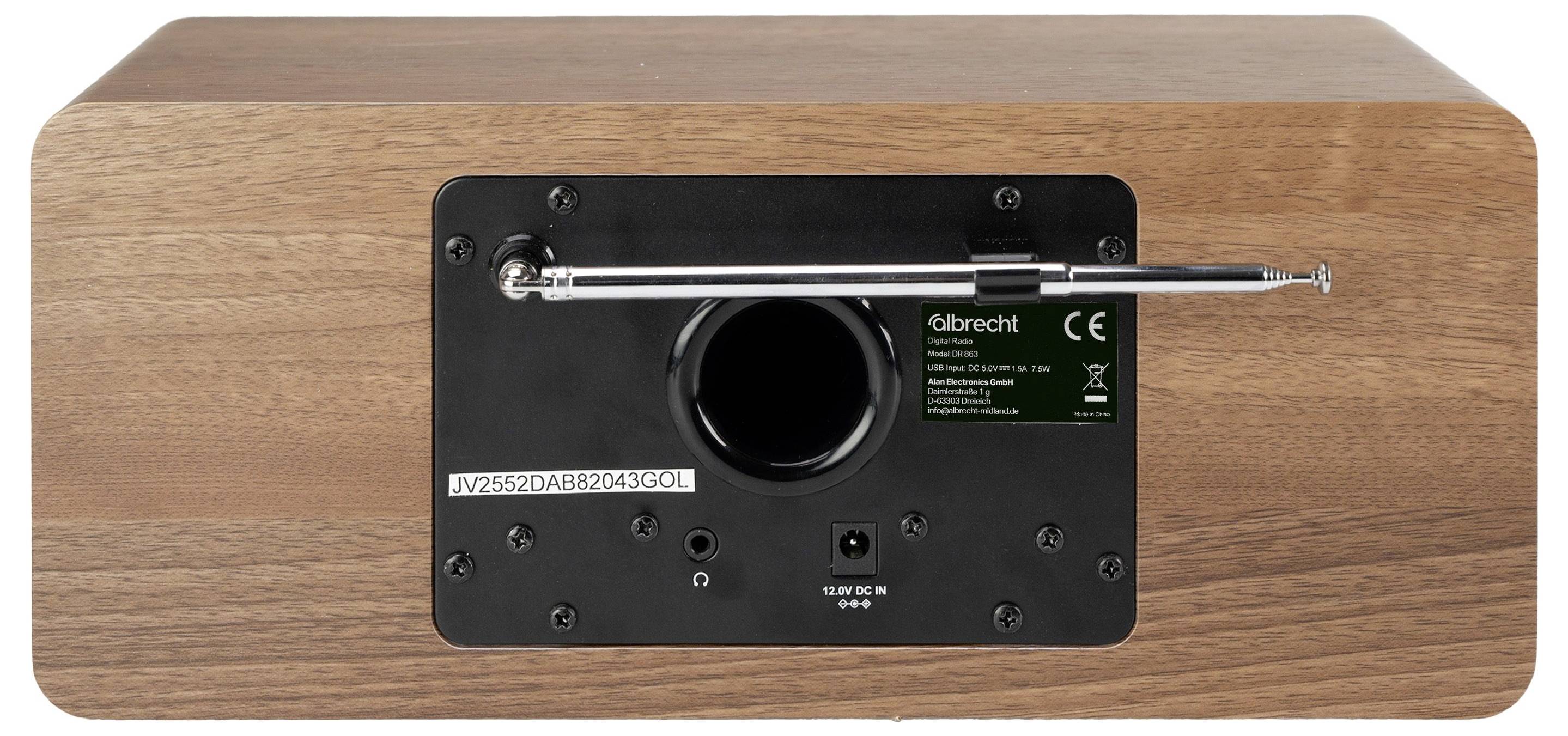 Rückseite eines Holzlautsprecher- oder Radiokabinetts mit schwarzem Bedienfeld, zentralem rundem Anschluss, Metallstab und kleinem Etikett.