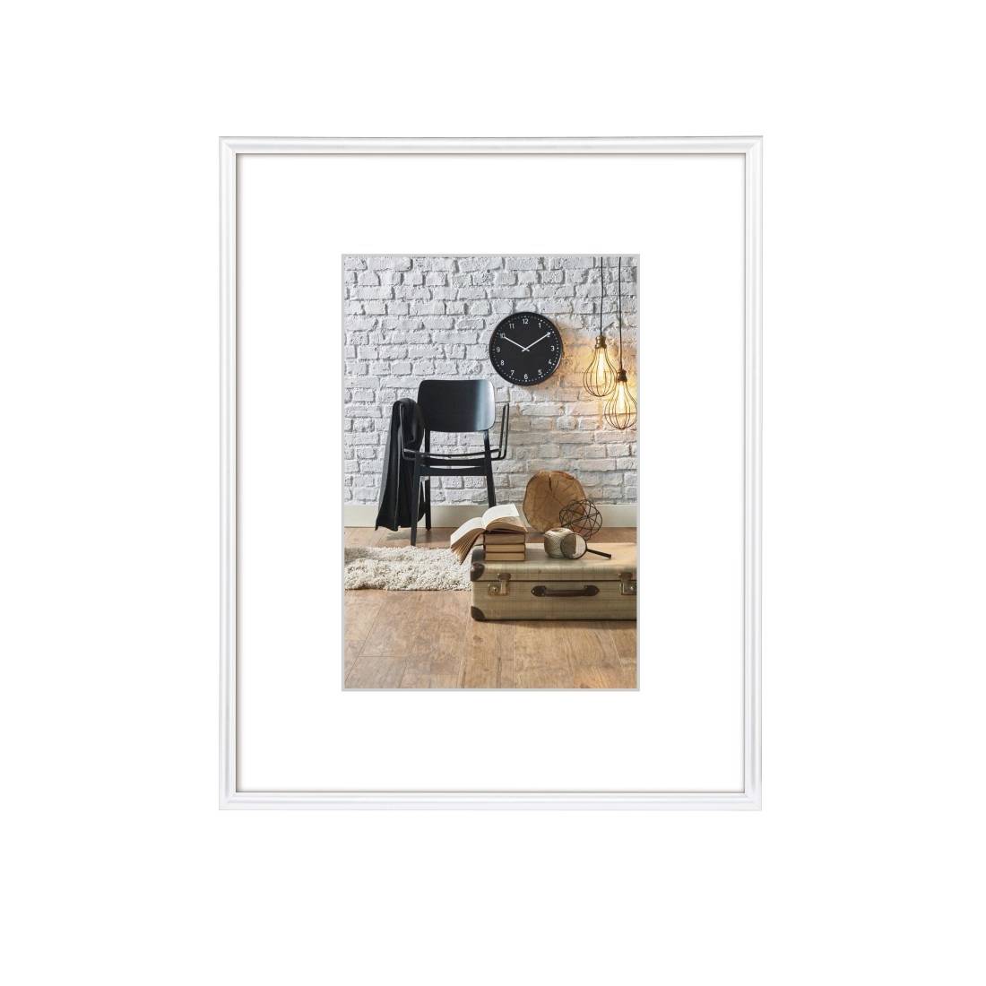 Gerahmtes Innenfoto eines Stuhls neben einer Backsteinwand-Uhr, hängender Leuchte, Büchern und einem Koffer auf einem Holzboden.
