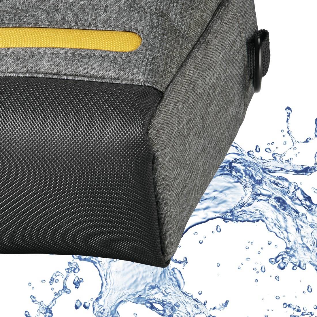 Ecke einer grauen Stofftasche oder eines Rucksacks mit schwarzem strukturiertem Panel und gelbem Reißverschluss, mit Wasser bespritzt, um Wasserbeständigkeit zu suggerieren.