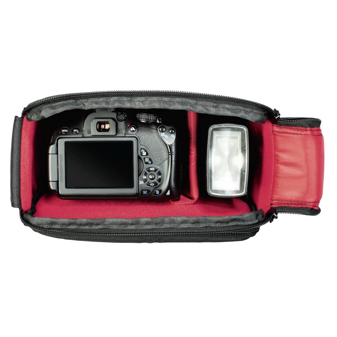 Offene Kameratasche mit DSLR-Kamera und Blitz in roten gepolsterten Fächern auf weißem Hintergrund.