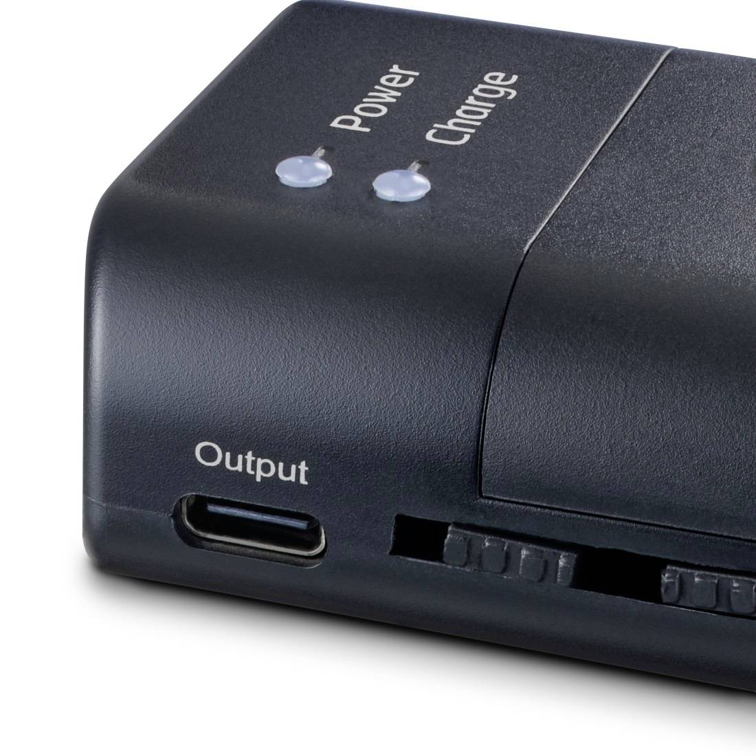 Nahaufnahme einer schwarzen Powerbank mit Stromversorgungs- und Ladeanzeigeleuchteten, einem USB-C-Ausgangsanschluss und einem seitlichen Schiebeschalter.