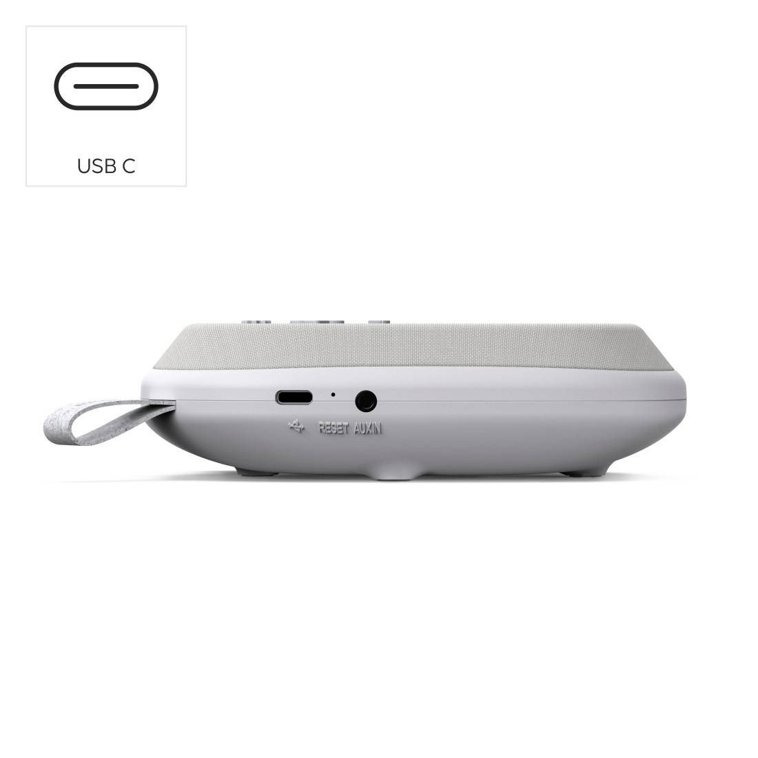 Tragbarer Lautsprecher von der Seite gezeigt mit einem USB-C-Anschluss und einer grauen Stoff-Trageöse, die angebracht ist.