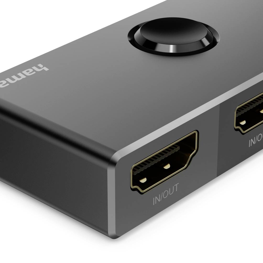 Nahaufnahme einer schwarzen HDMI-Schalterbox mit einer runden oberen Taste und zwei als 