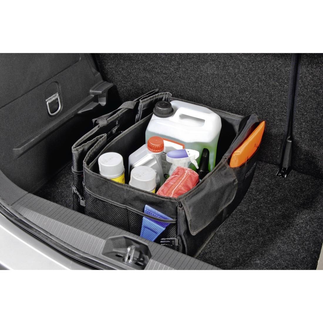 Offene Kofferraumorganisertasche, die verschiedene Flaschen und Behälter enthält, darunter einen großen weißen Behälter und Reinigungsmittel, die im Ladungsbereich eines Fahrzeugs gesichert sind.