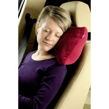 Schlafende Frau, die ihren Kopf auf einem roten Nackenkissen auf einem Autositz ablegt, trägt ein violettes Oberteil und einen Sicherheitsgurt.