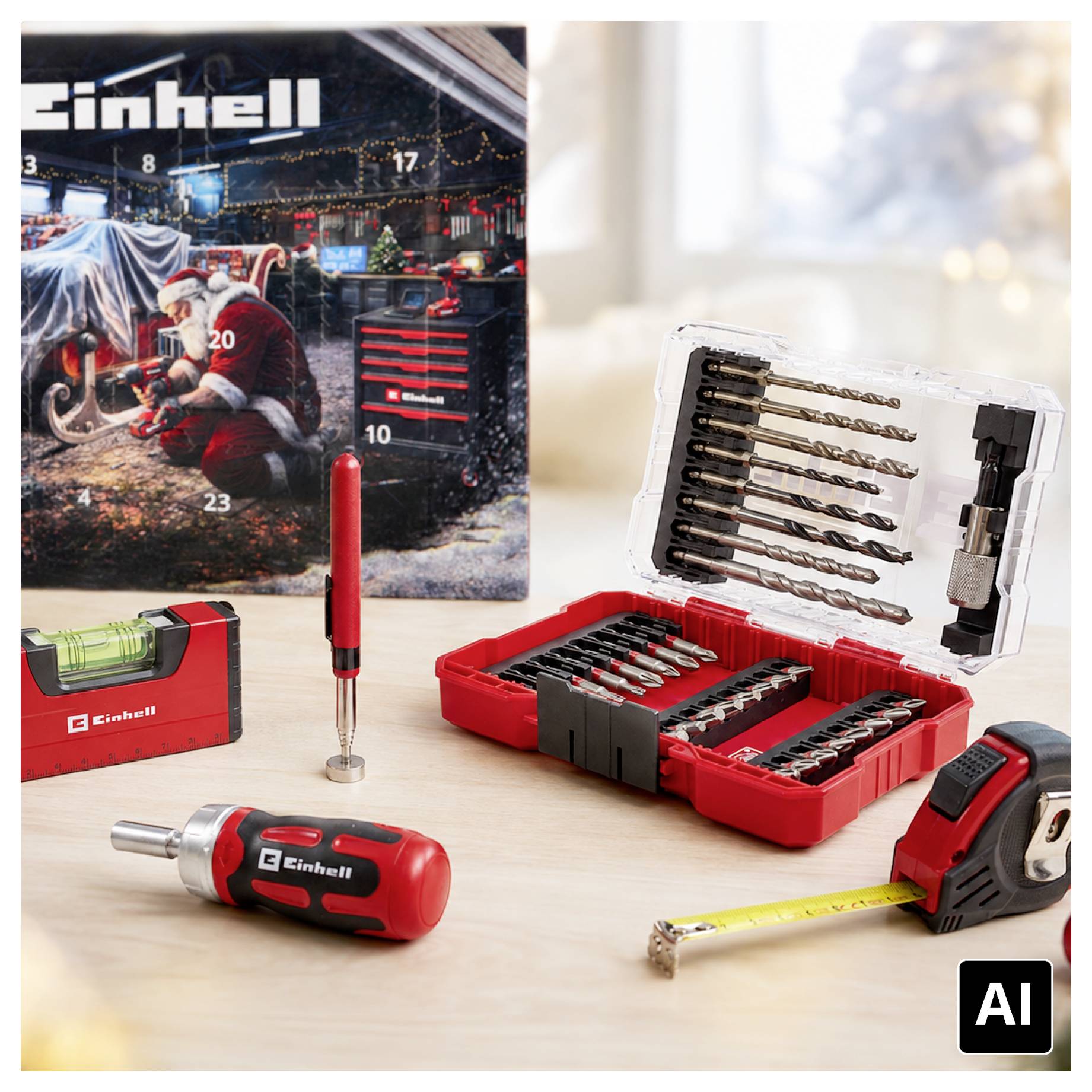 Einhell Bohr- und Schrauberbitsatz mit rotem Koffer, Stahlmaßstab, Schraubendreher und Produktverpackung auf einem Tisch ausgestellt.