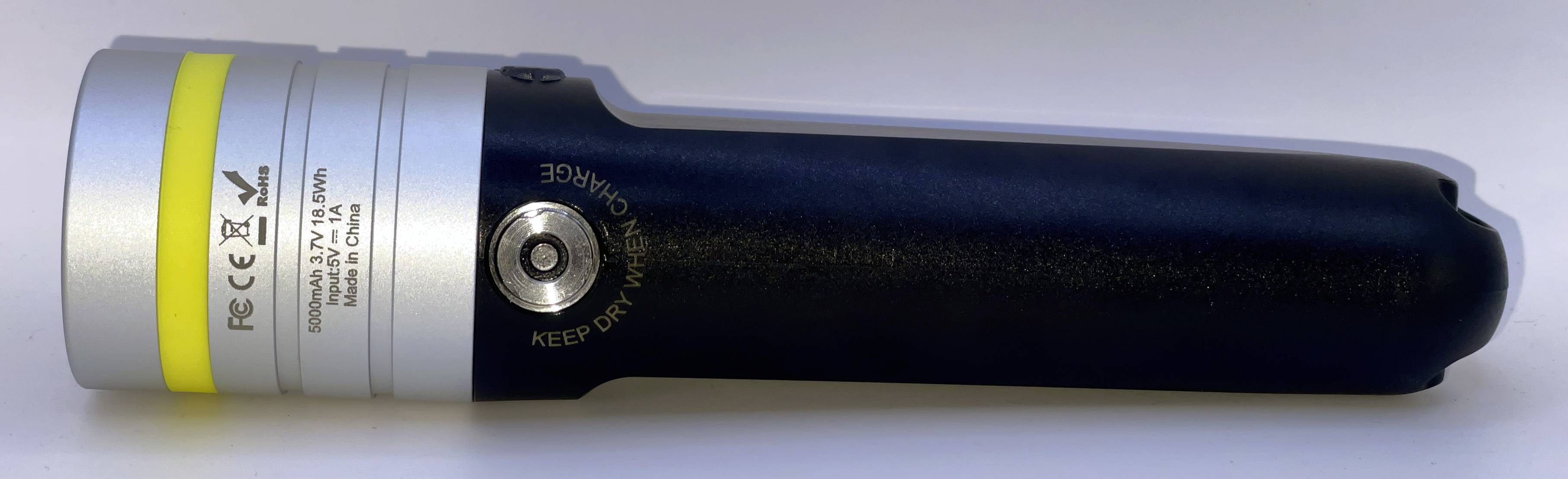 Batteriebetriebenes tragbares Gerät in Seitenlage, mit silbernem und dunkelblauem Gehäuse, einem gelben Band und einer runden Schaltfläche „KEEP DRY