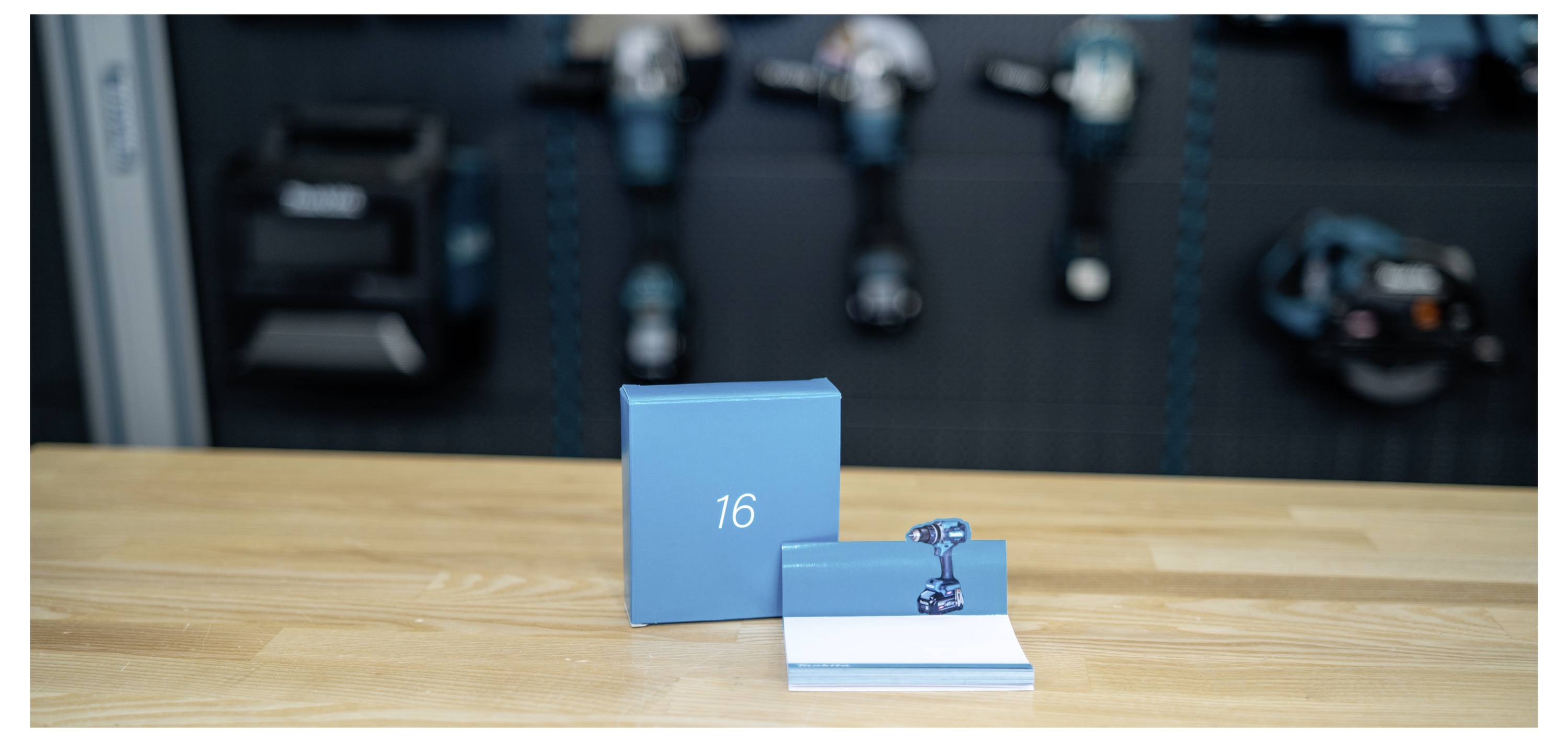 Blaue Produktschachtel und offenes Booklet mit einem kleinen Metallteil, mit der Nummer 